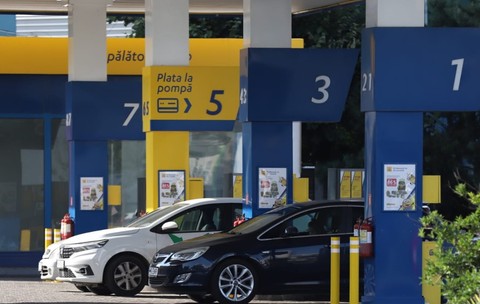 Două mașini așteptând să alimenteze la benzinărie