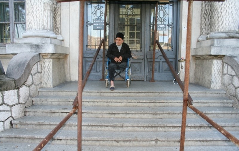 Bătrân în scaun cu rotile, umilit sistematic de instituţiile statului