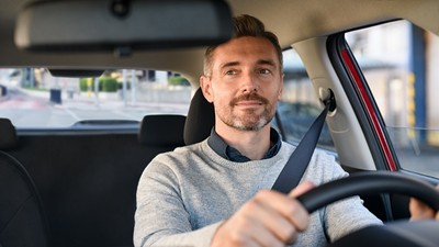 Mid,Adult,Man,Smiling,While,Driving,Car,And,Looking,At