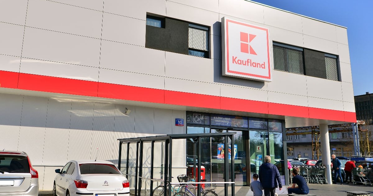Intrarea într-un magazin Kaufland, mașinile sunt parcate în fața supermarketului