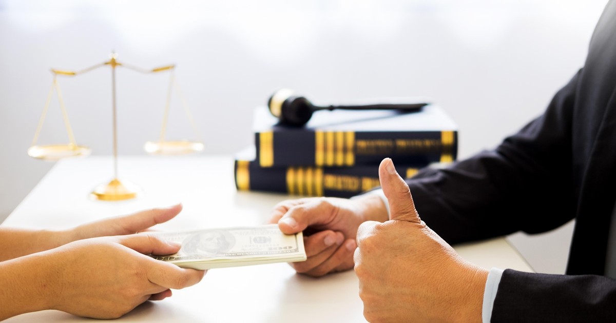 Poză cu un avocat (dreapta) care primește bani de la un client (stânga)
