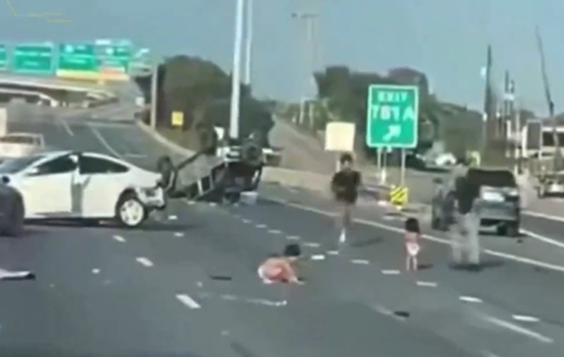 Doi copii mici aruncați din mașina tatălui lor, într-un accident, filmați când merg de-a bușilea pe autostradă, în SUA | VIDEO