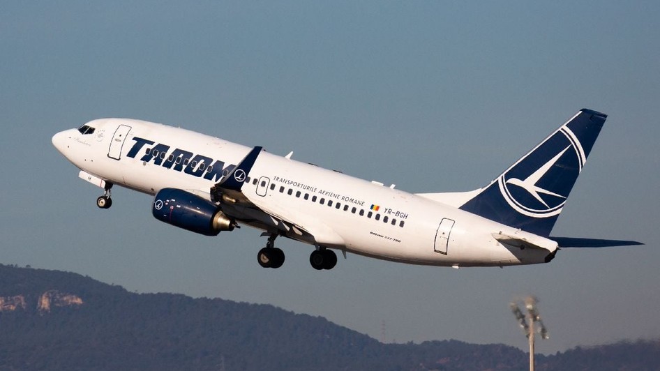 O fotografie a unui avion al companiei TAROM zburând.