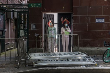 Două femei blocate în complexul rezidențial așteaptă o livrare de mâncare în Shanghai | FOTO: EPA