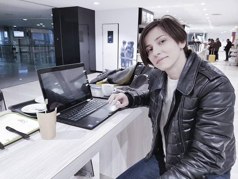 dana Rogoz, în aeroprotul din Torino, cu laptopul deschis în fața ei