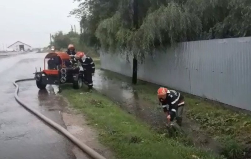 Imaginile zilei: Localnici la adăpost de ploaie, în timp ce pompierii le desfundă şanţurile. Reacţia primarului (FOTO&VIDEO)