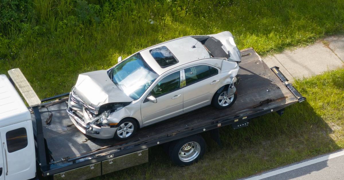 masina gri lovita in urma unui accident urcata pe o platforma auto