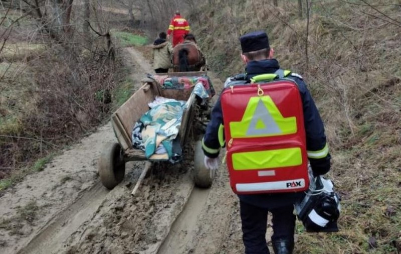 România, în secolul al XXI-lea: o bolnavă din Gorj este dusă la ambulanță cu căruța, pe un drum plin de noroaie