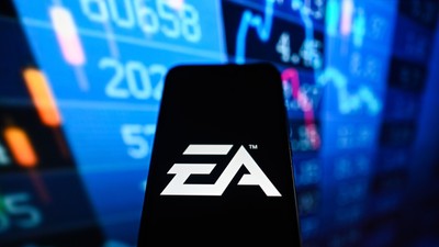 O siglă Electronic Arts (EA) este afișată pe un smartphone cu procente de la bursă pe fundal. Foto Hepta