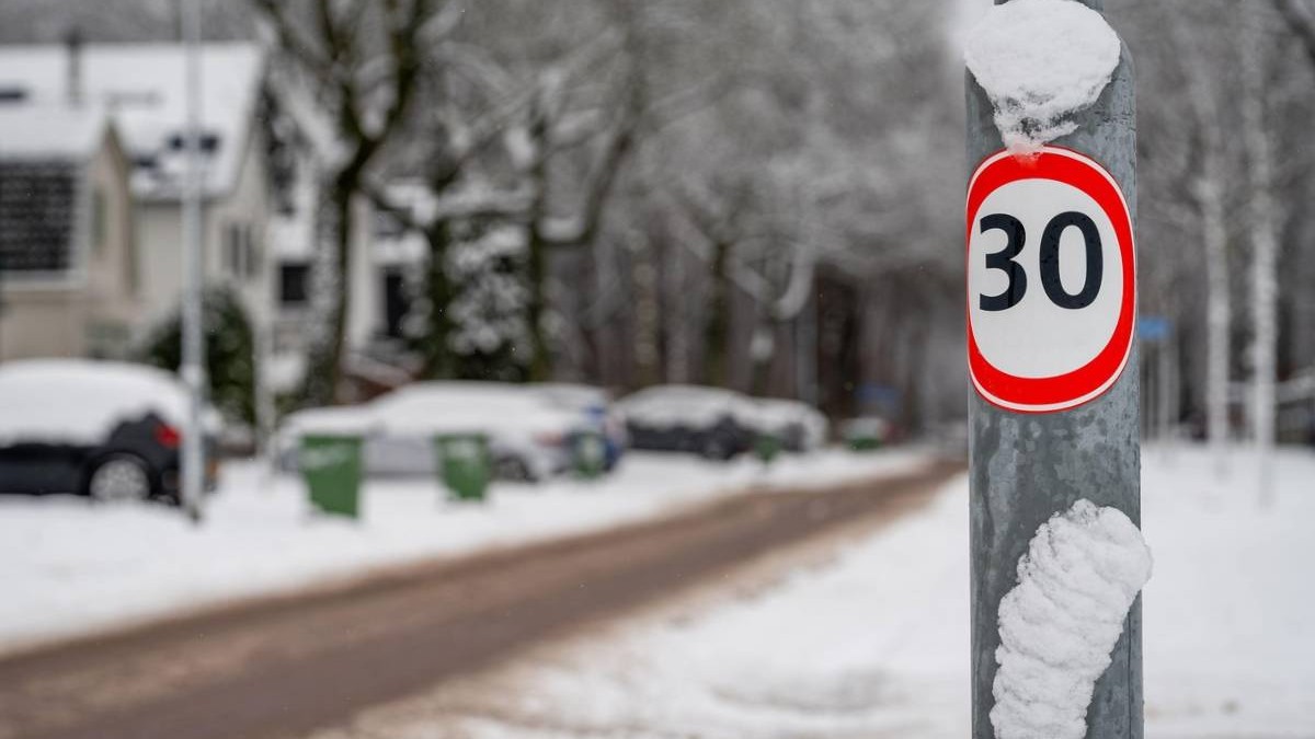 Indicator de limitare a vitezei de 30 km pe oră într-un cartier rezidențial acoperit de zăpadă