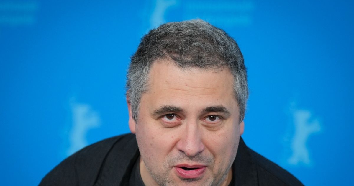 Radu Jude îmbrăcat într-o cămașă neagră vorbește în timpul unuei conferințe de presă de la Berlin International Film, februarie 2025