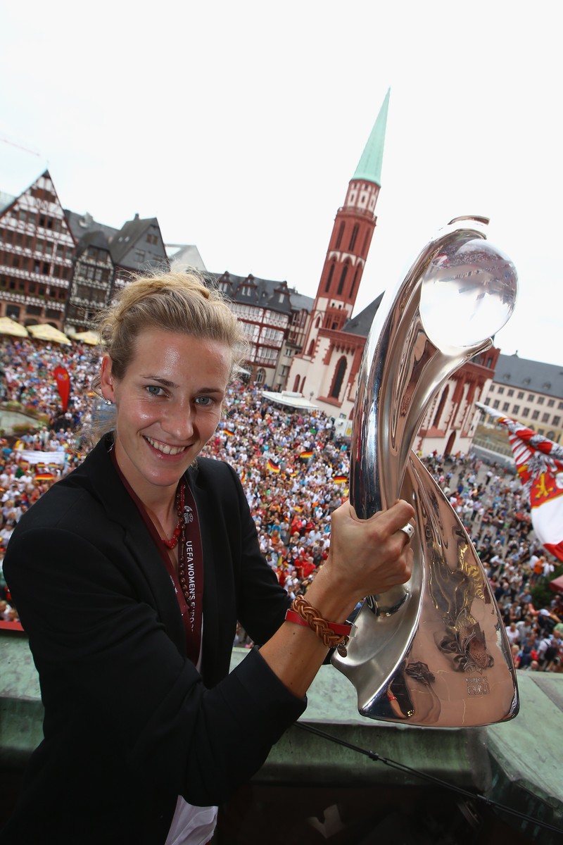 Nemțoaica de origine română Simone Laudehr, prezentând trofeul pentru UEFA Women's EURO 2013, de la balconul primăriei din Frankfurt pe Main. Foto: EPA