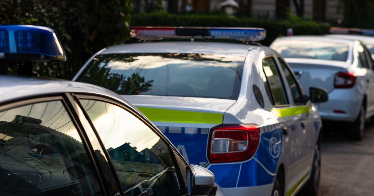 Mașină de Poliție, parcată între alte mașini pe stradă