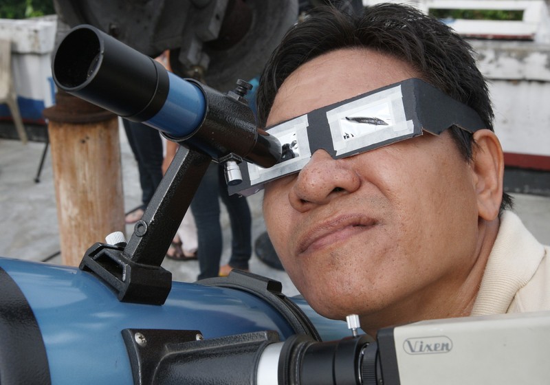 epa03251088 A Filipino watches the Venus transit through filtered glasses and a telescope at the Philippine Geophysical and Atmospherical Services Administration observatory in Quezon City, east of Manila, Philippines, 06 June 2012. Astronomy enthusiasts all over Asia looked to the skies on 06 June to watch the planet Venus crawl across the face of the sun in a rare celestial spectacle that will not happen again for more than a century. Venus appeared as a small black dot on the massive surface of the sun as it passed directly between the Earth and the center of the solar system in its last transit in this century. The next time Venus can be observed transiting the Sun will be in 2117. EPA/ROLEX DELA PENA