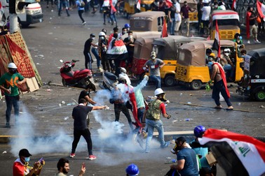 Protestatarii irakieni reactionează după ce poliția a tras gaz lacrimogen asupra lor în timpul unui protest în piața al-Tahrir, centrul Bagdadului, Irak, 29 octombrie 2019 / EPA