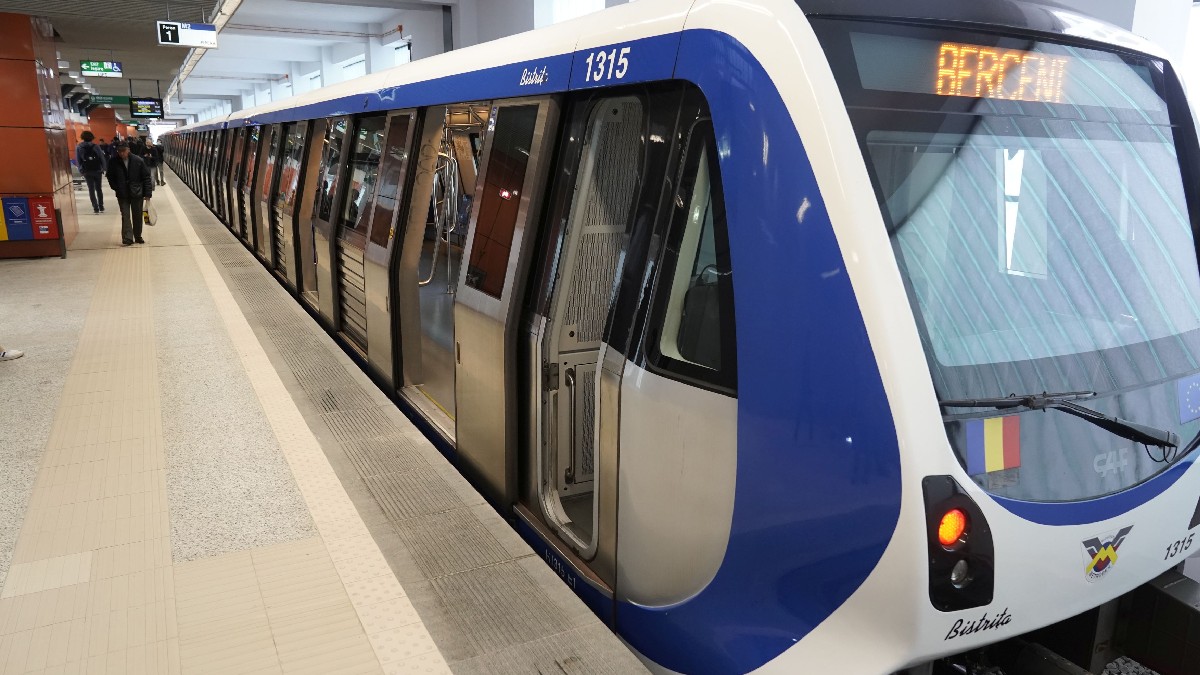 stație de metrou. un metrou în stație și câțiiva oameni pe peron