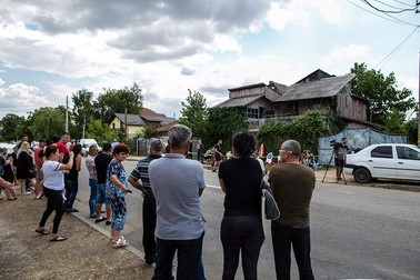 Oameni care stau în fața casei lui Dincă