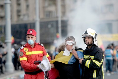 Un protestatar afectat de gazele lacrimogene este condus catre ambulanta de catre paramedici, in timpul mitingului de protest al cetatenilor romani rezidenti in strainatate, "Protestul Diasporei", vineri 10 august 2018, in Piata Victoriei din Bucuresti. Hepta