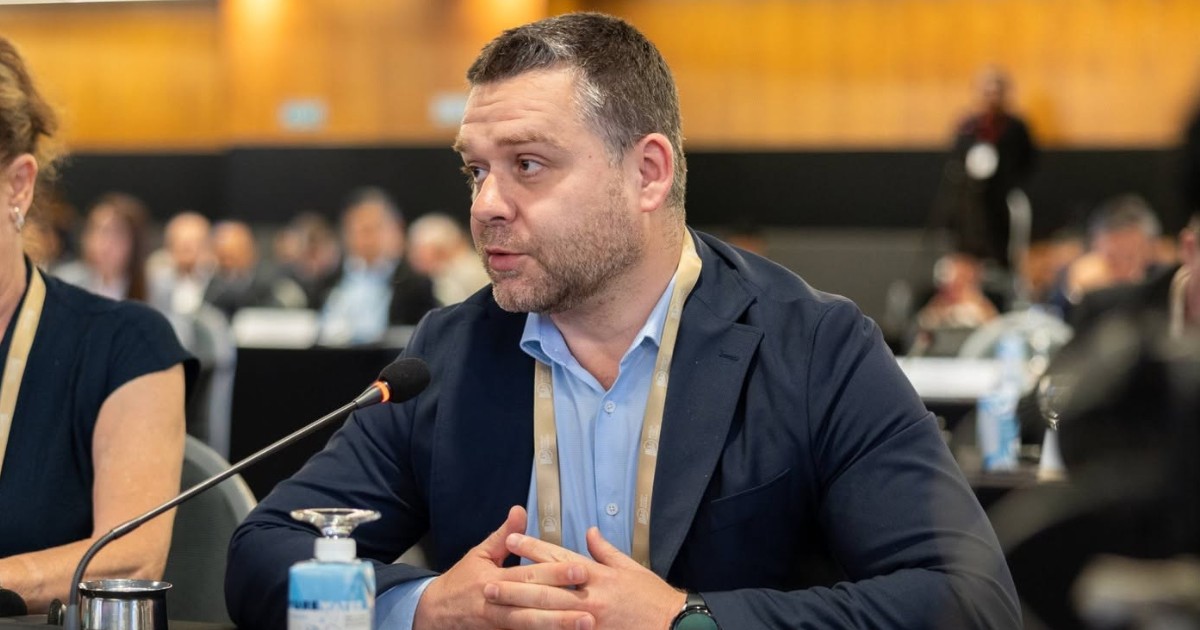 Primarul Capitalei, Ciprian Ciubu, îmbrăcat într-un sacou albastru și cămașă albastră, în timpul unei conferințe în care vorbește șa microfon