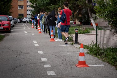Elevii așteaptă la rând să intre în liceu
