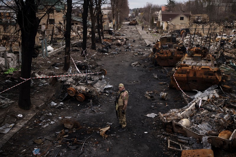 Un militar ucrainean stă în mijlocul tancurilor rusești distruse în Bucha, 4 aprilie 2022. Foto: Profimedia