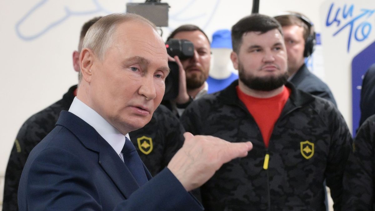 Vladimir Putin gesticulează din mâini la o reuniune