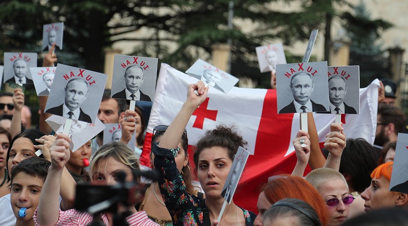 Activiști georgieni participă la un miting de protest față de politica rusă pentru Georgia și în omagiu adus memoriei celor uciși în conflictul de război dintre Georgia și Rusia din august 2008, în fața clădirii Secției de interese a Federației Ruse a Ambasadei Elveției în Georgia, în Tbilisi, Georgia, 7 august 2018 | Foto: EPA