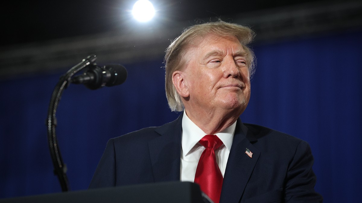 Președintele american Donald Trump, cu un costum albastru și o cravată roșie, în timpul unui discurs