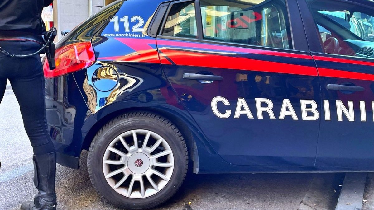 Imagine mașină de poliție in Italia, langa ea un polițist in picioare
