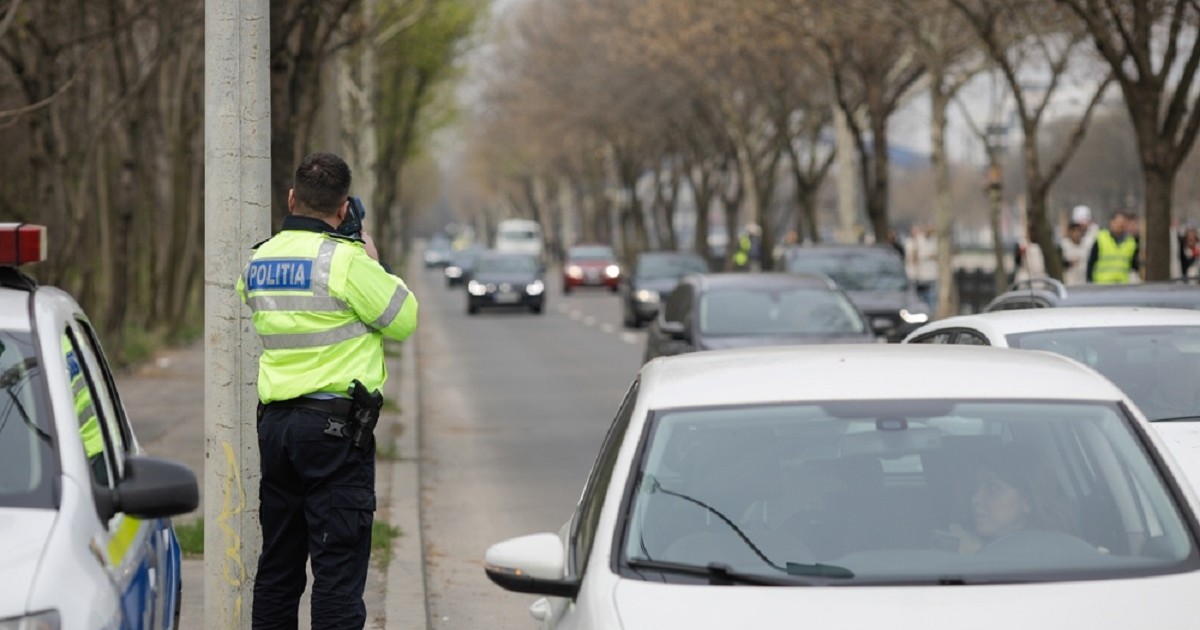 Cum poţi contesta o amendă de circulaţie - Imagine cu un poliţist de circulaţie care operează aparatul radar pe un bulevard din Bucureşti