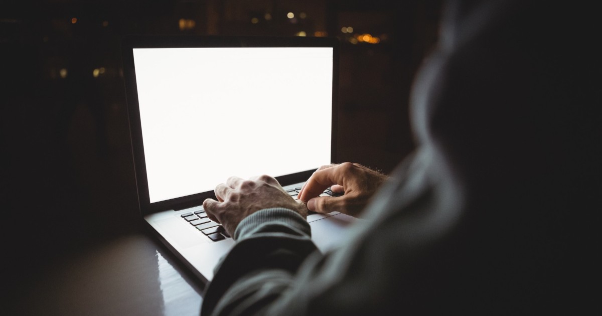 În imagine este ilustrat un bărbat care tastează pe un laptop
