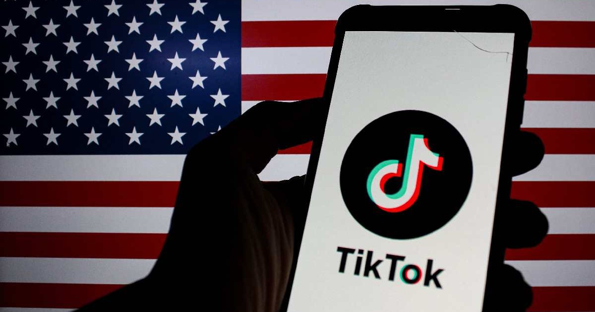 Sigla TikTok este afișată pe un smartphone cu steagul Americii în fundal.