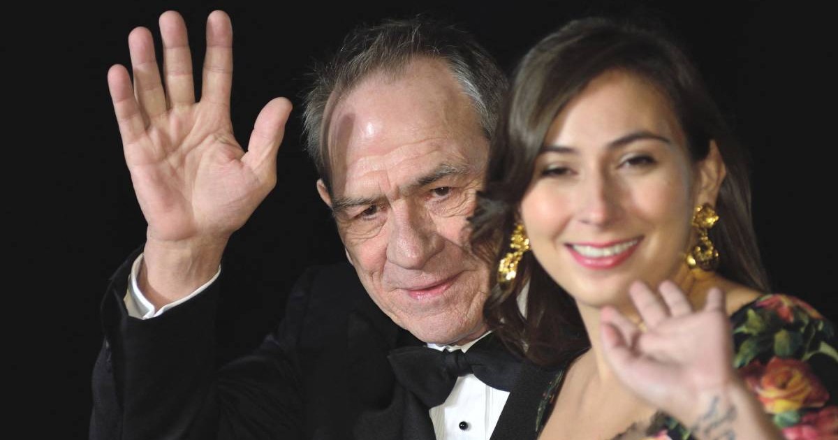 Actorul Tommy Lee Jones, in costum negru si papion, si fiica sa, Victoria Jones, care face si ea cu mana, 2027