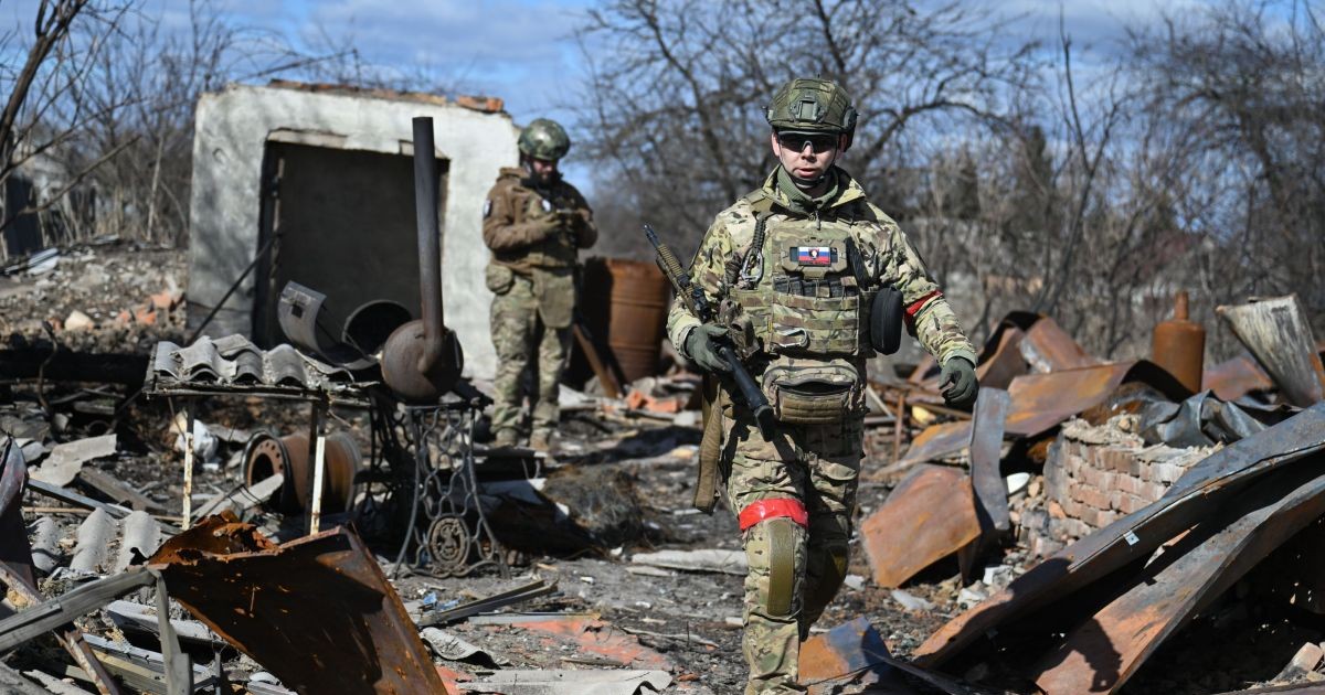 Doi militari ruși patrulează într-o zonă recent capturată de la ucraineni din orașul Sudja, regiunea Kursk, Rusia, aprilie 2025