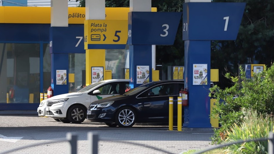 Mai multe autoturisme sunt staționate la pompele de alimentare ale unei stații de carburant.