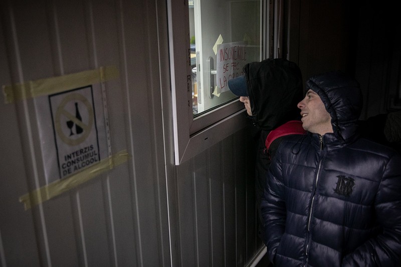 Costeluș și prietenul lui se uită pe geam să vadă ce se întâmplă în adăpost. Sunt nerăbdători să intre. Așteaptă de câteva ore.