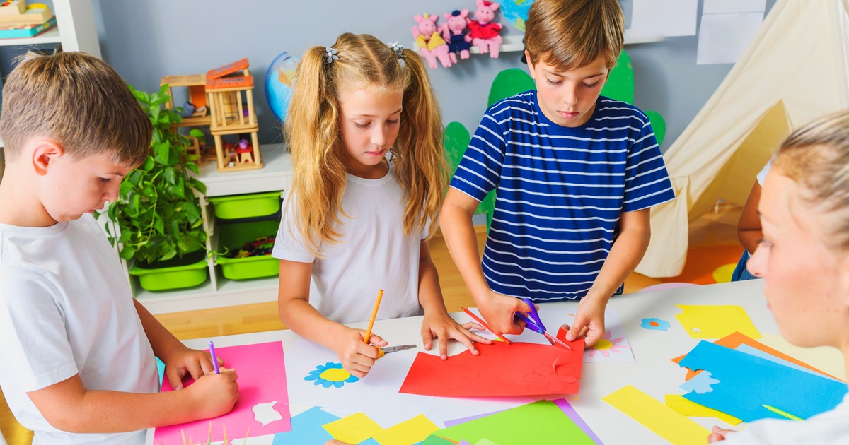 4 copii, 2 baieti si 2 fetedeseneaza si taie hartie colorate