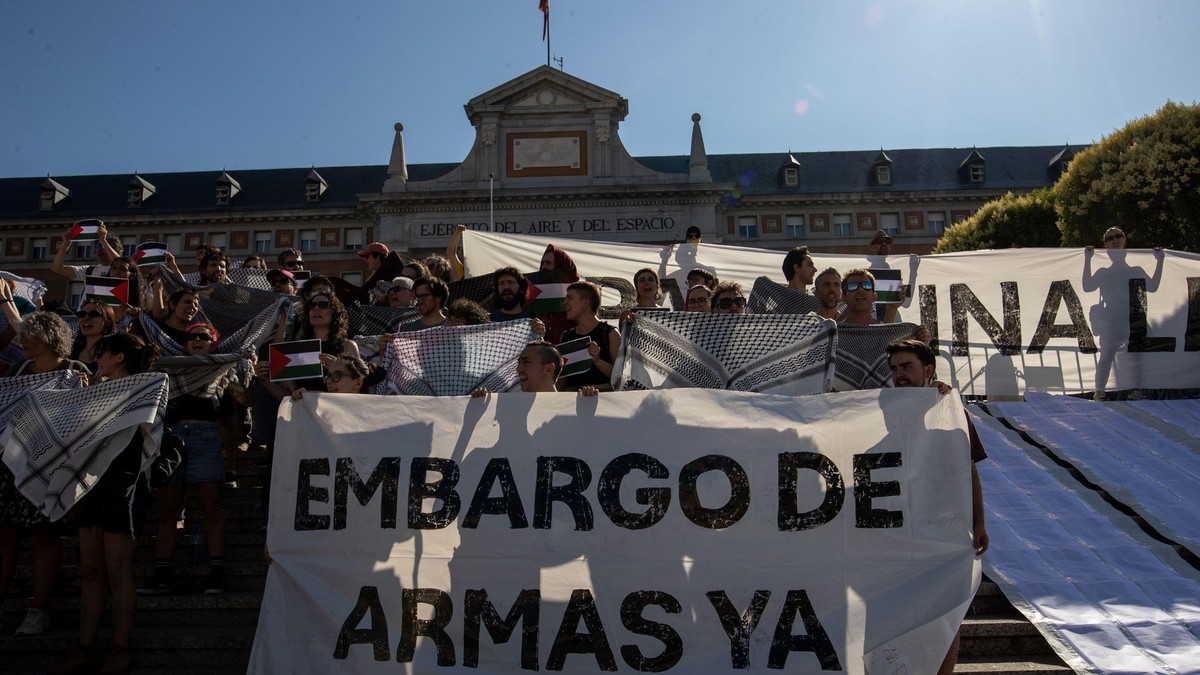 Imagine cu mai mulți protestatari care țin un afiș cu mesajul: „Embargo asupra armelor acum”