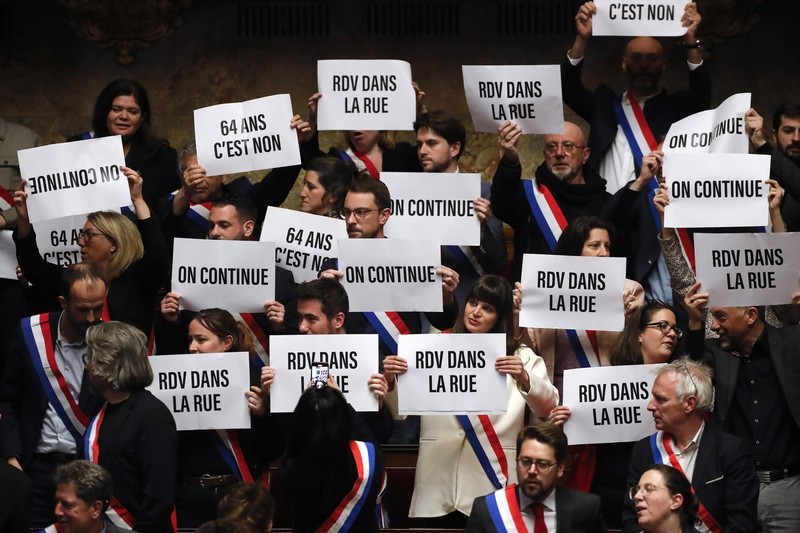 epa10534153 French left-wing parliamentary groups members of the 'Nupes' coalition (New Popular Ecological and Social Union) brandish slogans after the first motion of no-confidence against the government was rejected at the National Assembly in Paris, France, 20 March 2023. The centrist and independent group LIOT has tabled a motion of censure co-signed by the left-wing parliamentary groups of the 'Nupes' coalition (New Popular Ecological and Social Union) and far right-wing deputies of RN (Rassemblement National) have tabled each one a motion of censure against the government of Prime Minister Borne after the application of Article 49 paragraph 3 of the Constitution to adopt the controversial pension reform law without a vote. EPA-EFE/TERESA SUAREZ
