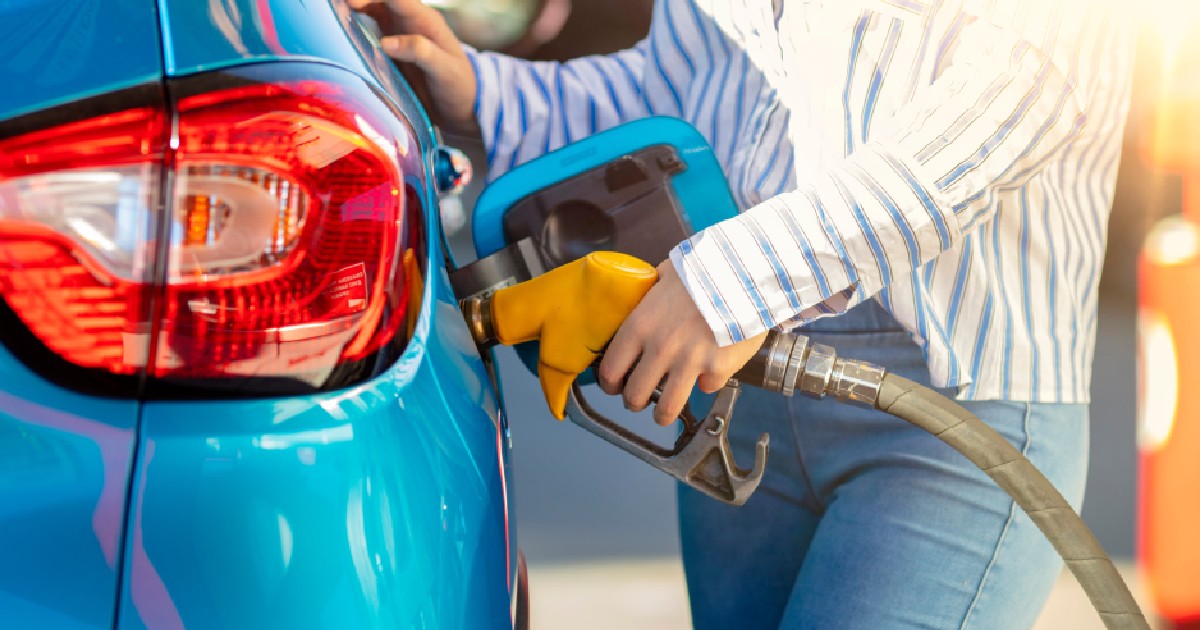 O femeie alimentează mașina cu carburant la stația de benzină.