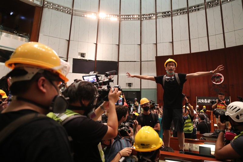 epa07687510 A protester gestures as he speaks after breaking into the main chamber of the Legislative Council building during the annual 01 July pro-democracy march in Hong Kong, China, 01 July 2019. Protesters are demanding the resignation of Hong Kong Chief Executive Carrie Lam and the full withdrawal of a suspended extradition bill. On 01 July, Hong Kong marks the 1997 transfer of sovereignty of Hong Kong from Britain to China. EPA-EFE/RITCHIE B. TONGO