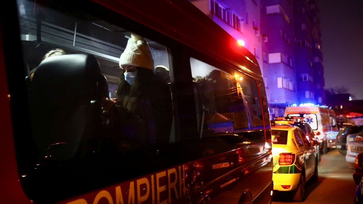 Un echipaj SMURD în prim-plan, iar pe fundal mașini de Poliție și Ambulanță, noaptea, cu girofarele pornite
