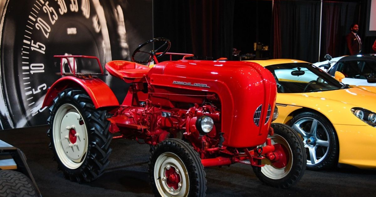 Un tractor roșu Lamborghini este parcat lână alte mași la un salon auto, iulie 2025