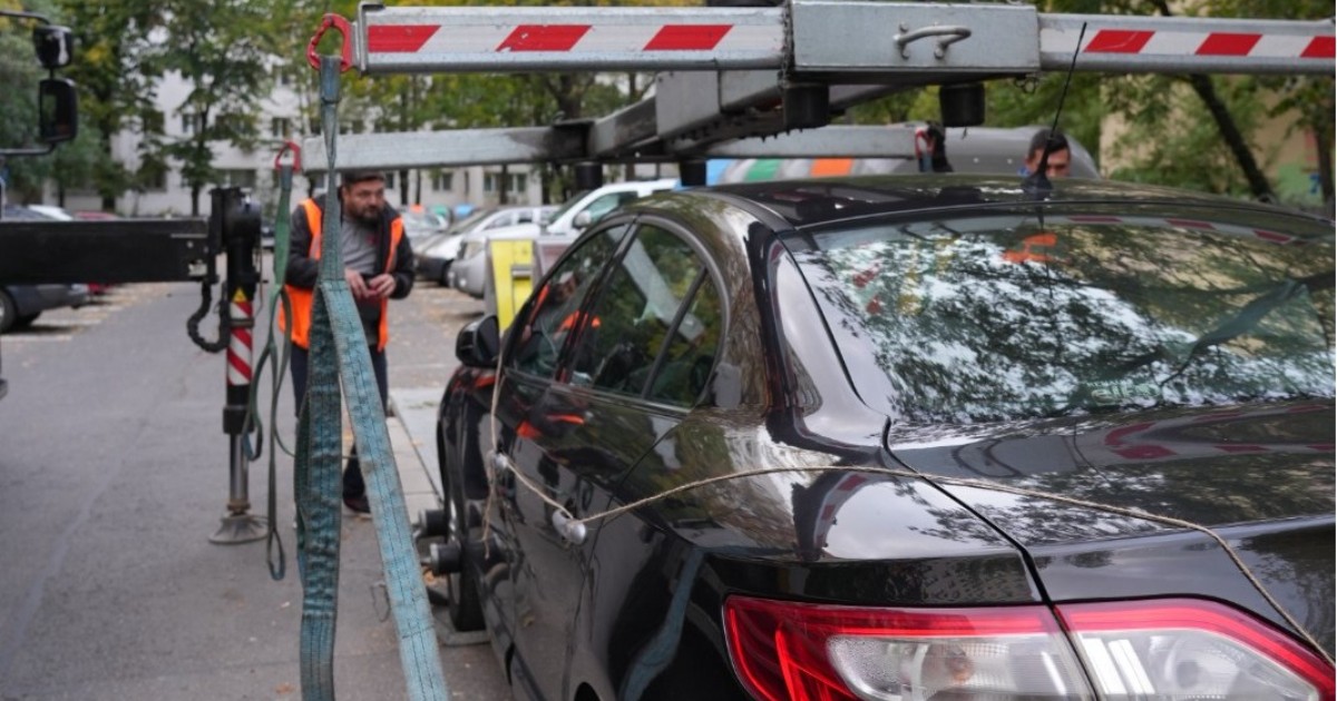 Poliția Locală în timp ce ridică pe platformă o mașină care a fost parcată neregulamentar în Sectorul 3