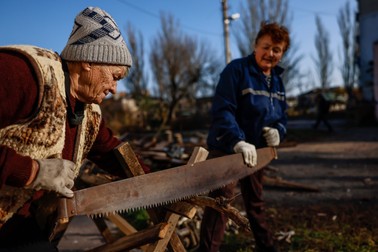 Nadiya și Natascha taie lemne de foc într-un sat aflat în imediata apropiere a frontului, în nordul regiunii Herson, Ucraina, 5 noiembrie 2022 | Foto: Profimedia