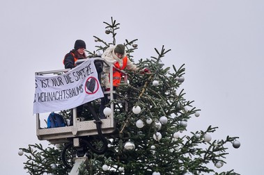 Două activiste pentru mediu din grupul Letzte Generation taie vârful bradului de Crăciun de la Poarta Brandenburg din Berlin - 21 decembrie 2022. Prin acțiunile lor, activiștii cer eliminarea imediată a utilizării combustibililor fosili | Foto: Profimedia Images