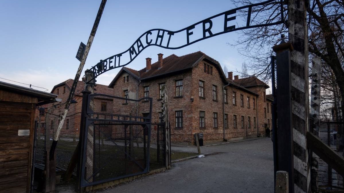poarta intrare Auschwitz pe care scrie in limba germana munca te va elibera. in spate lagarele de concentrare