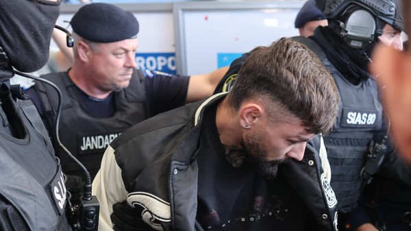 Vlad Baltateanu, escortat de politisti în afara Aeroportului International Henri Coanda din Otopeni, 6 octombrie 2026. Inquam Photos / George Calin