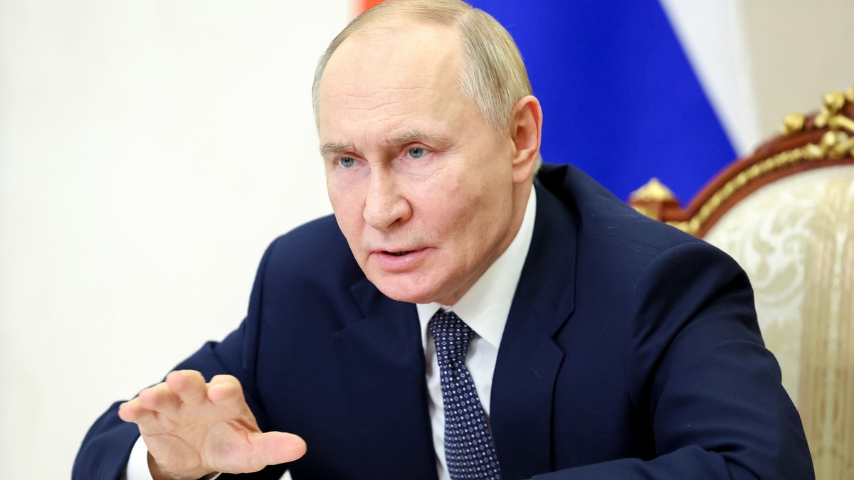 Vladimir Putin explică ceva gesticulând cu mâna, într-o manieră care atrage atenția că ceea ce spune e ceva serios