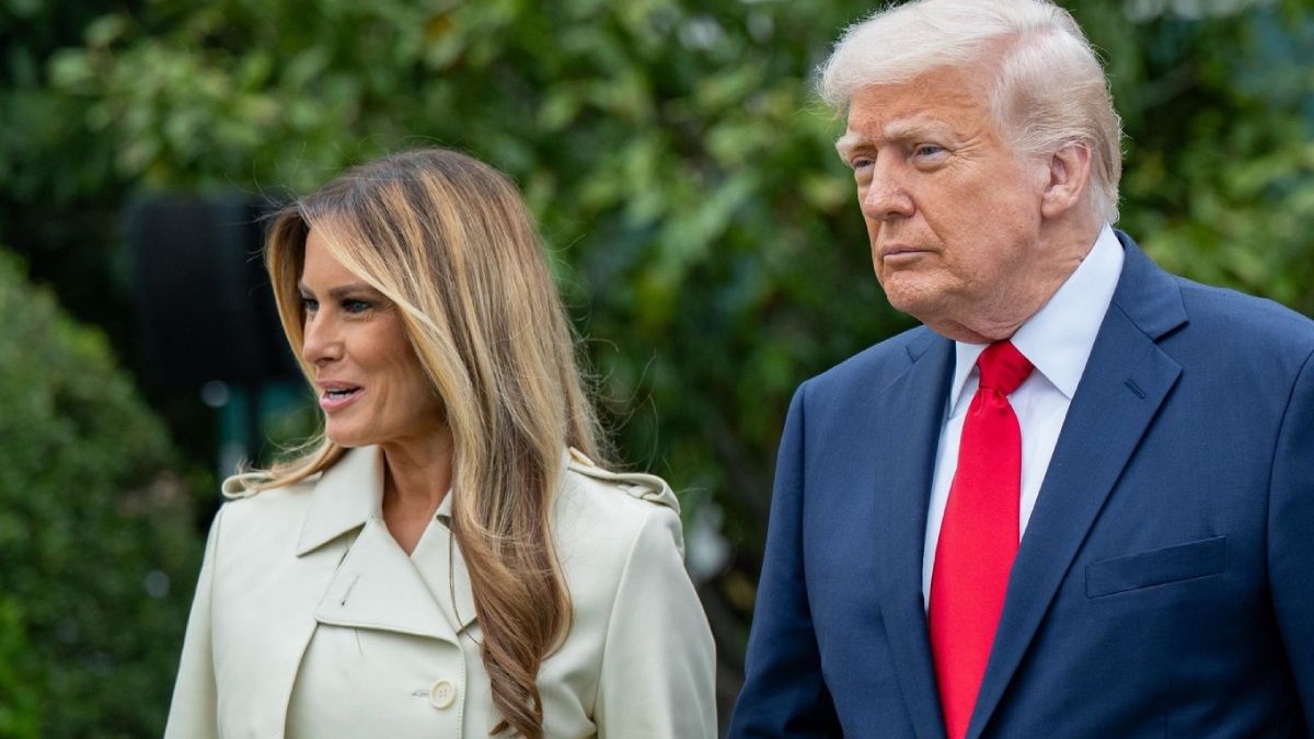 In imagine președintele Donald Trump, in costum inchis la culoare si cravata rosie, alături de el soția sa, Melania, intr-un pardesiu crem